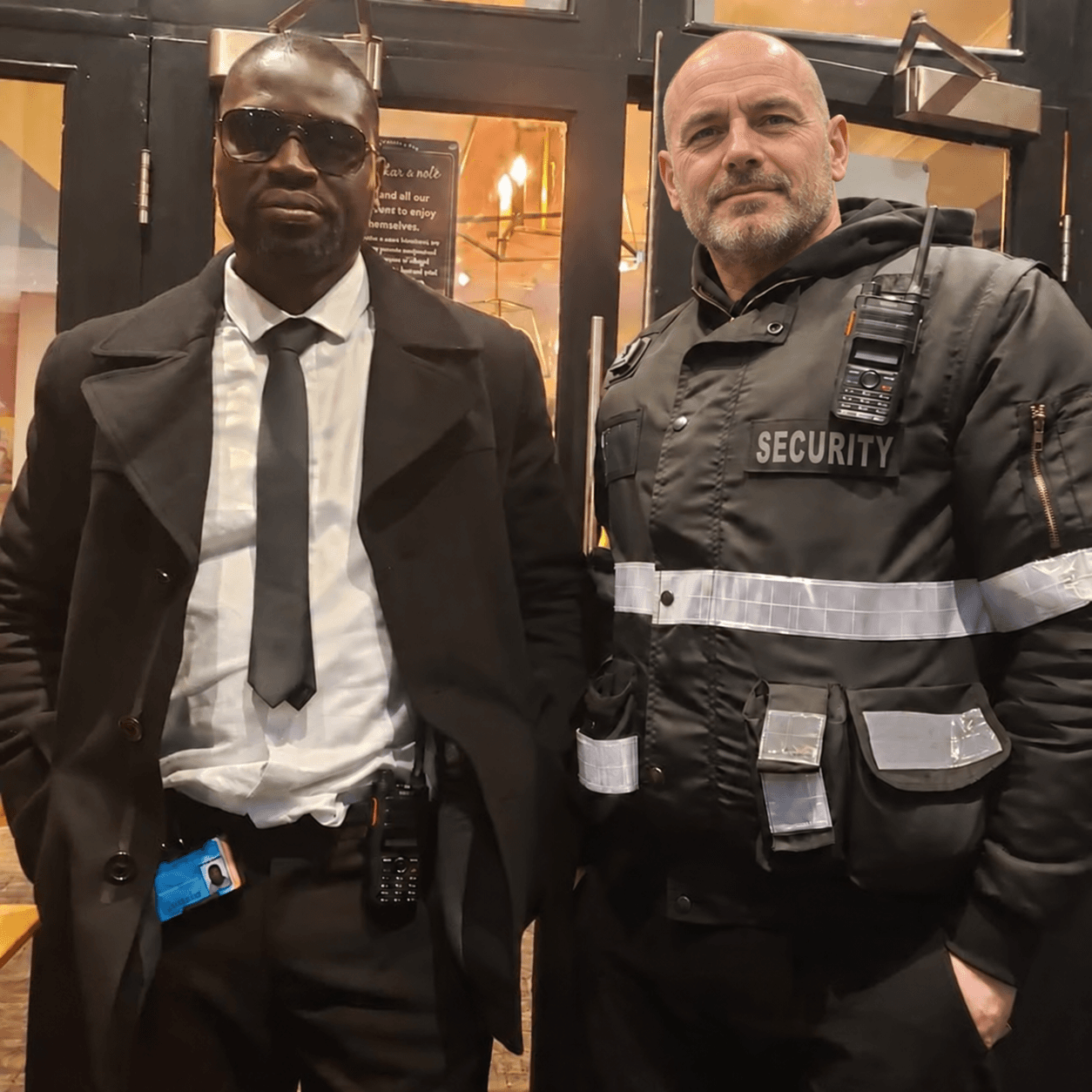 Two security professionals standing at a venue entrance.
